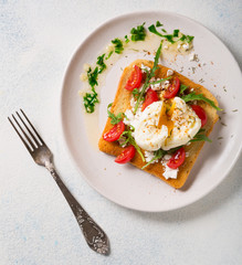 Healthy breakfast. Poached Egg on Toasted Toast with Cheese, Tomatoes and Arugula. top view with copy space