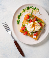 Healthy breakfast. Poached Egg on Toasted Toast with Cheese, Tomatoes and Arugula. top view with copy space