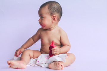 asian cute baby girl eating red dragon fruit. newborn baby on white background