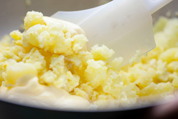 茹でたジャガイモと卵を混ぜる