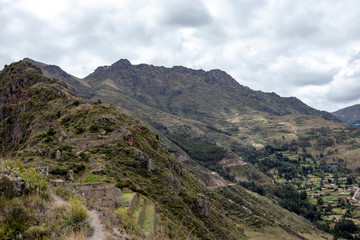 Naklejka na ściany i meble Landscape with green Andean Mountains and Inca ruins on the hiking path in Pisac archeological park, Peru