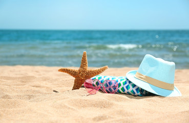 Set of different beach objects on sand near sea. Space for text