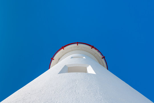 white lighthouse from below on a sunny day