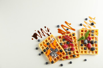 Flat lay composition with belgian waffles and different toppings, top view