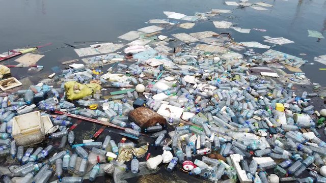 Plastic pollution trash in ocean with different kinds of garbage - plastic bottles, bags, wastes floating in water. Sea ocean water pollution concept. Plastic pollution crisis