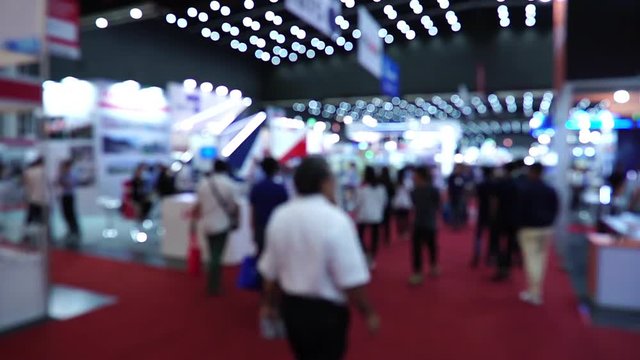 People walking in exhibition fair defocused background footage timelapse