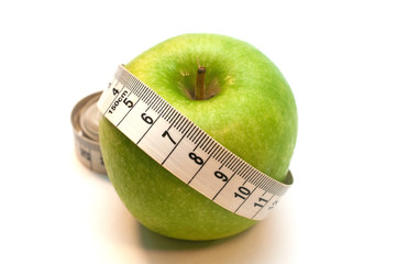 Green apple wrapped by measuring tape isolated on white background