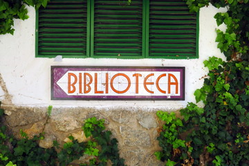 Fototapeta na wymiar Biblioteca. Panneau indicateur sous une fenêtre à volets..