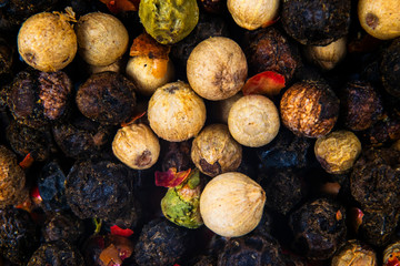 Colored dried pepper mix on. Red, black, white and green pepper close up.  Top view. Texture of...