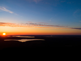 Fototapeta na wymiar Aerial view sunset sky background. Dramatic gold sunset sky with evening sky clouds over the lakes. Stunning sky clouds in the sunrise. Above the Sky landscape. Panoramic sky view.