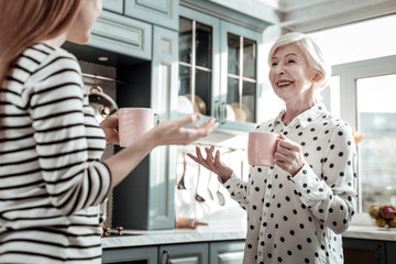 Two relaxed women using gestures while talking in the kitchen