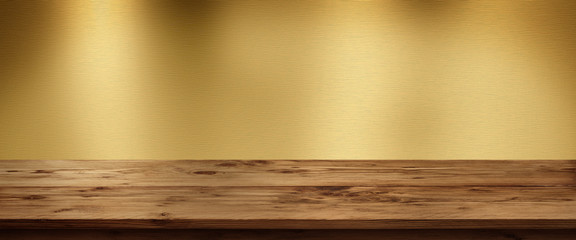 Golden metallic background with wooden table