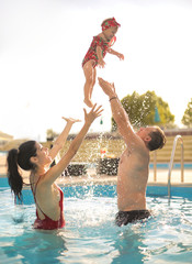 Family having fun in a swimmingpool - 278089511
