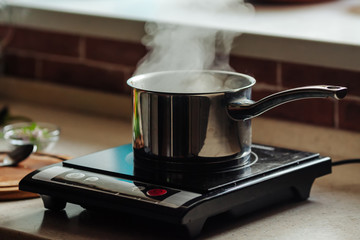 Saucepan with boiling water on the electric kitchen stove