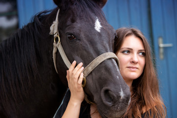 Obraz premium portrait of young woman with her black horse