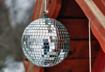 Mirror ball in drops of water, suspended on a wooden roof