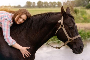 Obraz premium young woman sitting on her black horse