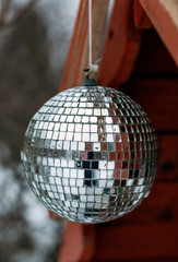 Mirror ball in drops of water, suspended on a wooden roof