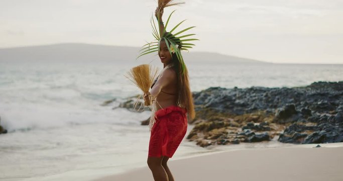 Beautiful polynesian woman performing a Tahitian hula dance on the beach