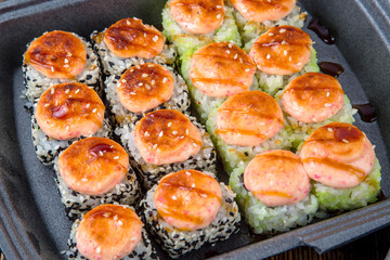 Set of baked rolls in a plastic box. Food delivery from sushi restaurant