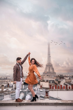 man and woman holding hands with Eiffel Tower background