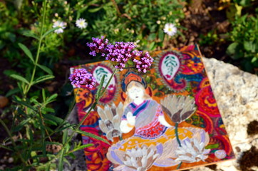 Obraz na płótnie Canvas Hand painted stained glass picture with Buddha on it. Stone and flower background,