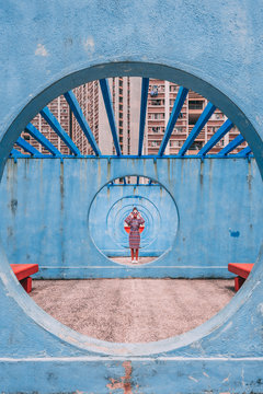 Woman standing in round blue concrete pathway