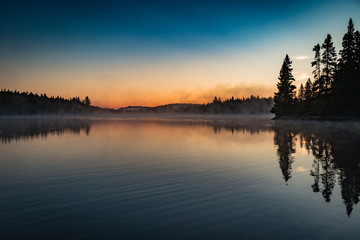 Fototapeta na wymiar Idyllic Sunrise Mirroring In The Lake - Parc de la Mauricie, Quebec
