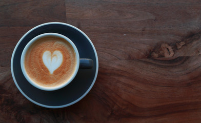 Macro photo cup of coffe cappucino in a yellow cup. Painted heart on skin coffe