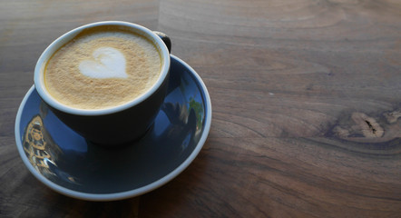 Macro photo cup of coffe cappucino in a yellow cup. Painted heart on skin coffe
