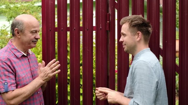 two farmers takling to each other on sunny day. They discuss important news