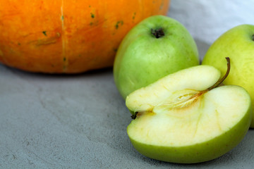 green apples on grey table. green apple and sweet pumpkin on grey background