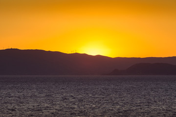 Sunset on the Saronic Gulf islands dotted with wind turbines