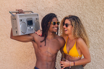 Young interracial friends listen music with an old radio