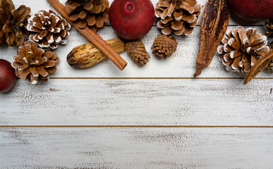 Christmas decorations on a white wood background with copy space. Pine cones, garland, berries and potpourri