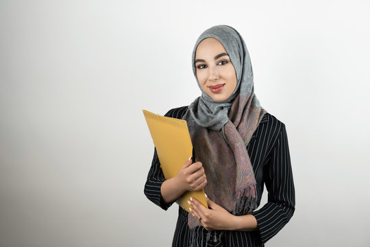 Young Beautiful Muslim Business Woman Wearing Turban Hijab Headscarf Holding Folder With Documents Isolated White Background