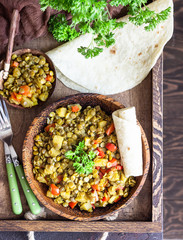 Green lentil stew (curry) with apple, bell pepper and onion. Selective focus. Dark stone background, rustic style.