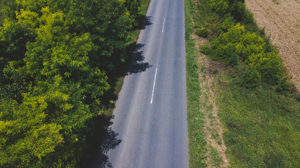 Asphalt road through fields and villages, aerial view