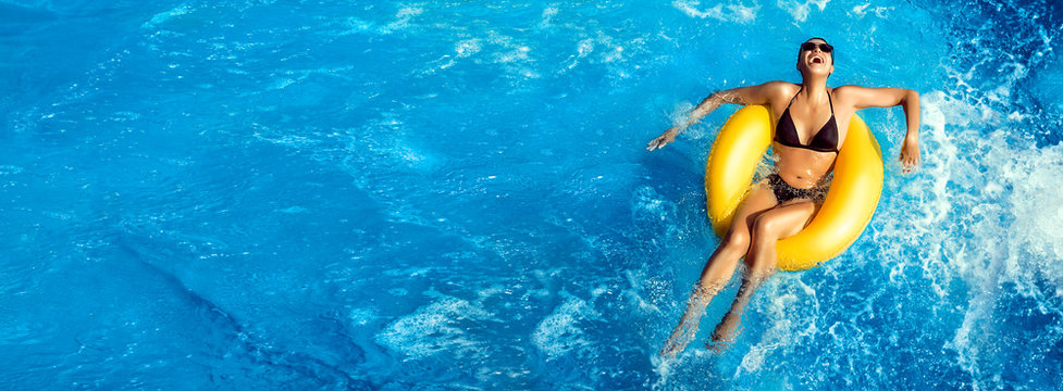 Summer vacation. Laughing young woman enjoying an aqua park. Fun in the pool