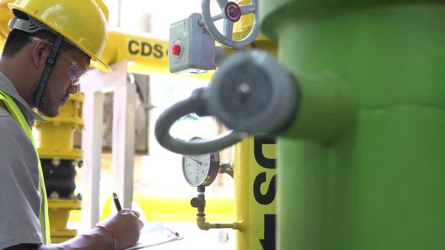 Asian Maintenance engineer at the waste water management system of a huge factory,maintenance checking technical data of heating system equipment,Thailand people	