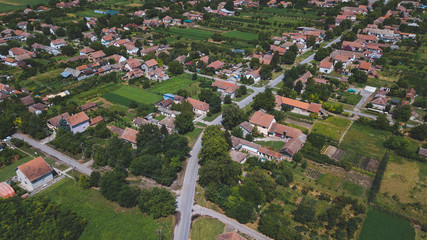 Asphalt road through fields and villages, aerial view