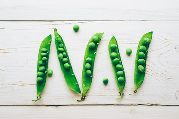 Fresh green peas on a white wooden table top view space for text 