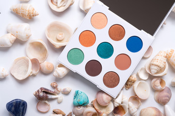 fashion summer eye palettes with  natural shells and gemstones around background. close up