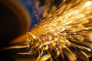 Worker cutting, grinding and polishing motorcycle metal part with sparks indoor workshop. Super...