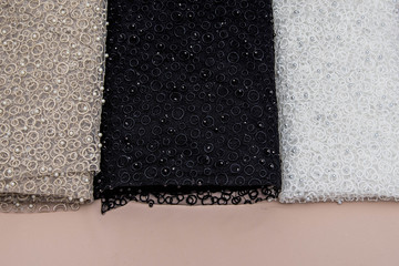 Texture lace fabric. lace on white background studio. thin fabric made of yarn or thread. a background image of ivory-colored lace cloth. White, black and beige lace on beige background.