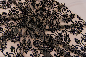 Texture lace fabric. lace on white background studio. thin fabric made of yarn or thread. a background image of ivory-colored lace cloth. Black lace on beige background.