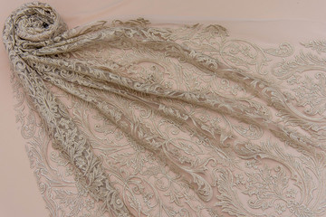 Texture lace fabric. lace on white background studio. thin fabric made of yarn or thread. a background image of ivory-colored lace cloth. Beige lace on beige background.