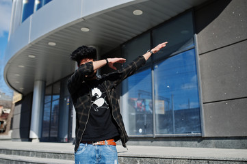 Beard asian man in casual wear posing against new modern building and show dab.