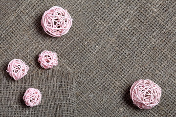 Coarse linen fabric. On it are rattan balls.