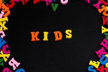 Multicolor kids is wood letter on black background